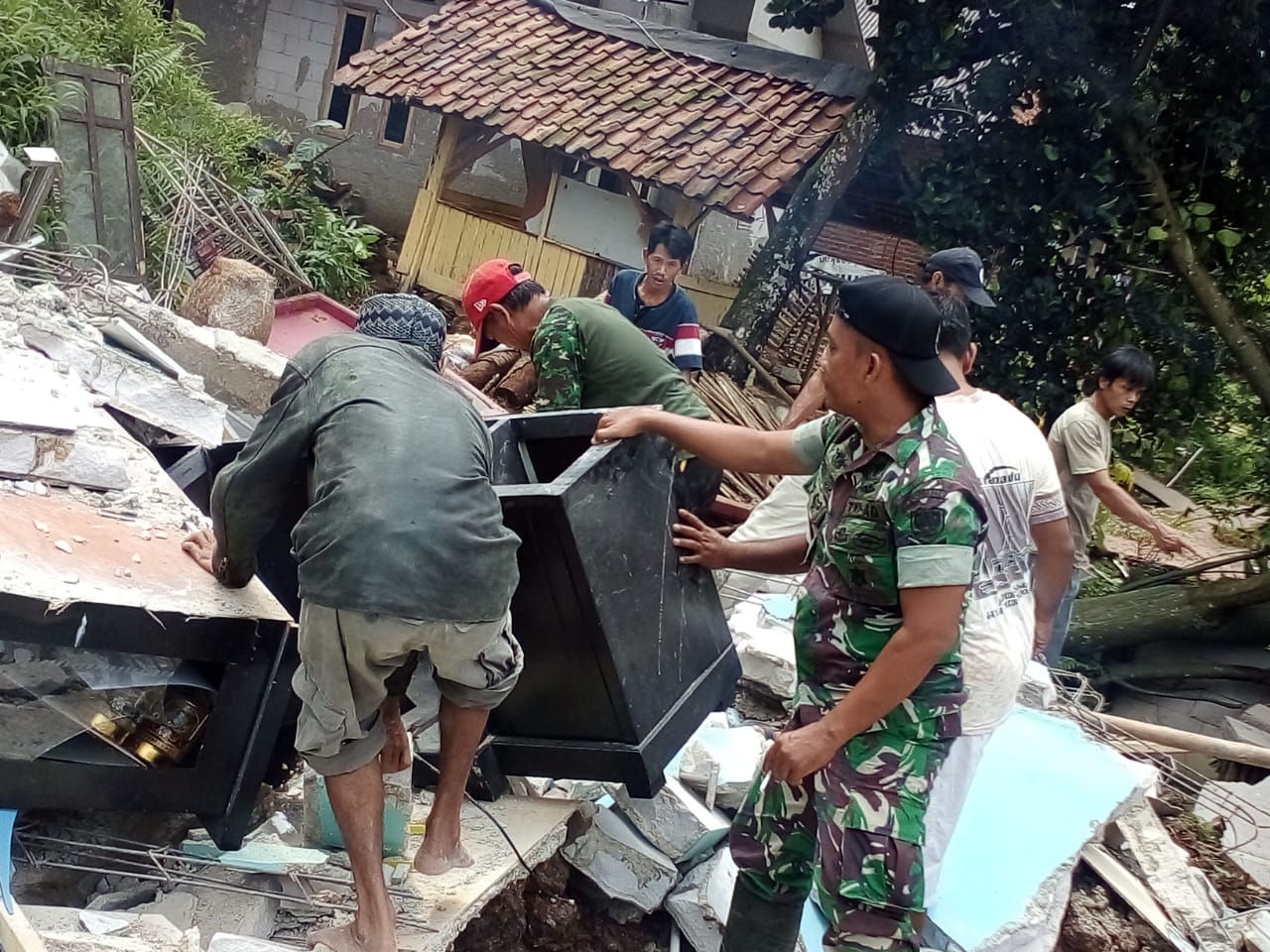 Danramil 2118/Cigudeg Kodim 0621/Kab. Bogor Bantu Evakuasi Korban Yang Rumahnya Roboh Tergerus Air Hujan
